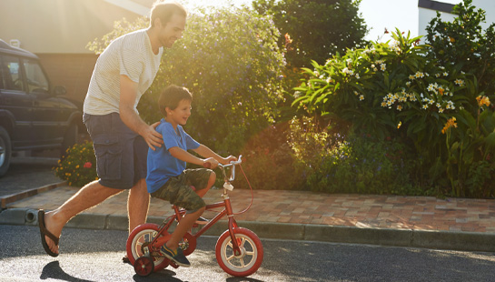 Father teaching son to ride a bike