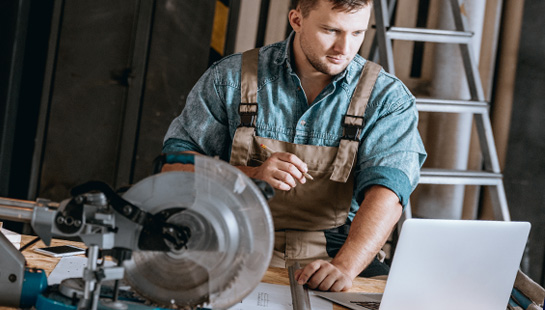 Small Business Owner in Workshop on Laptop