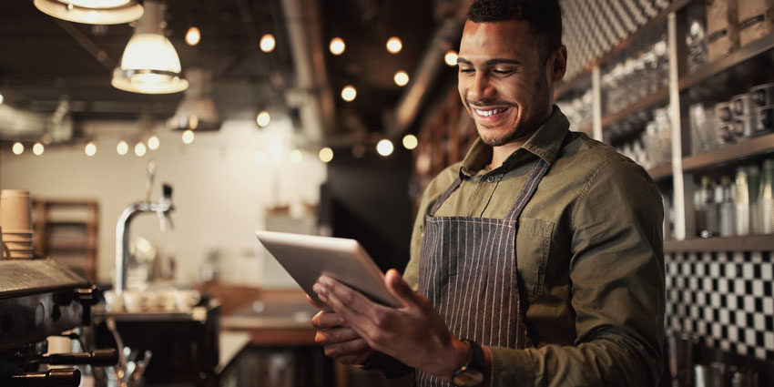 man in restaurant setting on working on tablet