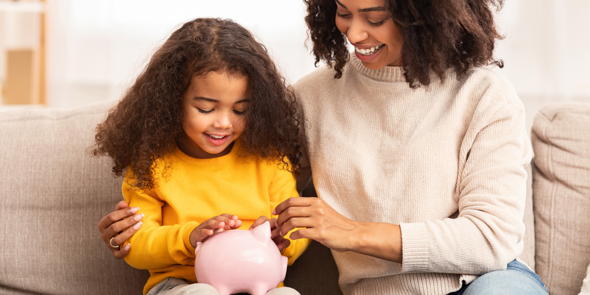 mother with daughter adding to piggy bank