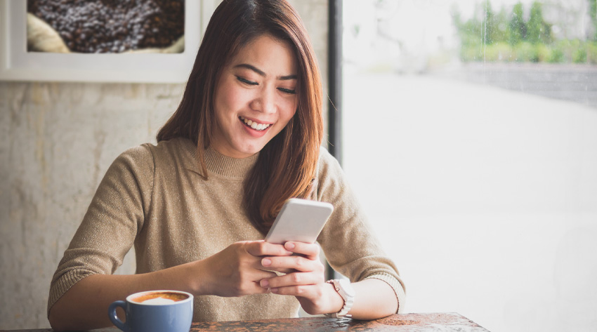 woman in coffee shop using mobile device